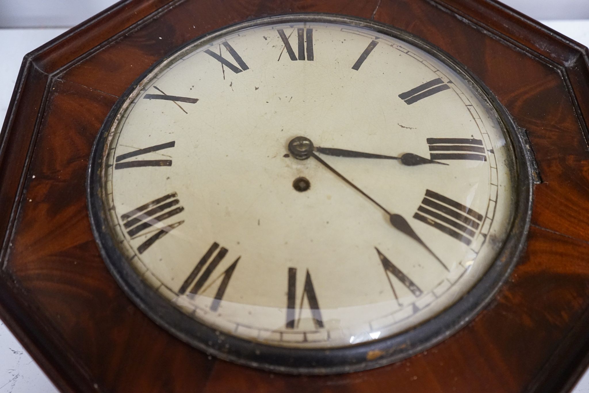 An early 19th century mahogany octagonal wall clock, 47cm